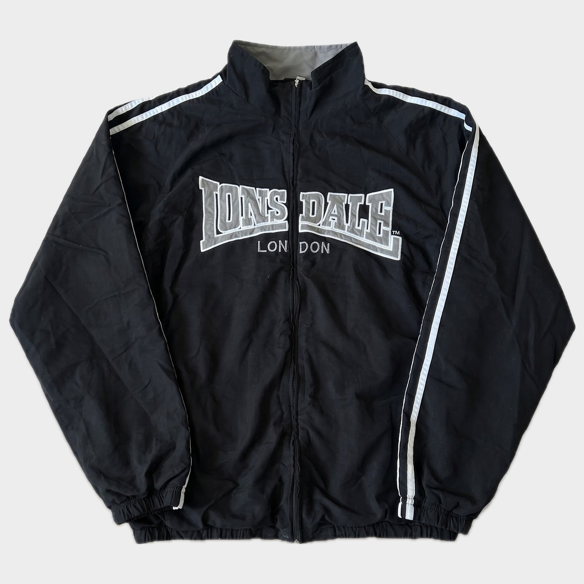 Glattes Liegefoto: Vintage Lonsdale Trackjacket (M) (KI-Aufbereitung, Zustand siehe echte Fotos)